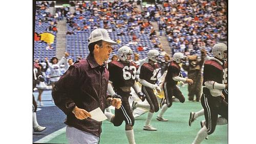 Coach Kimbrough Running onto the field with the football team